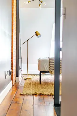 a living room with a floor lamp and a chair at Jungle House Luxury Stays - Columbus Downtown Short North in Columbus