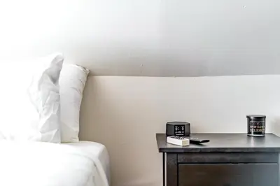 a bedroom with a bed and a table with a clock on it at Jungle House Luxury Stays - Columbus Downtown Short North in Columbus