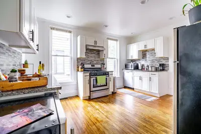 a kitchen with white cabinets and a stove top oven at Jungle House Luxury Stays - Columbus Downtown Short North in Columbus