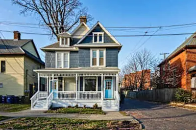a blue house with a white porch at Jungle House Luxury Stays - Columbus Downtown Short North in Columbus