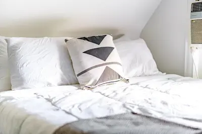 a white bed with pillows on top of it at Jungle House Luxury Stays - Columbus Downtown Short North in Columbus
