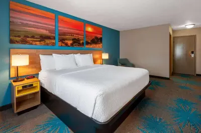 a large bed in a hotel room with a large white bed at Days Inn by Wyndham Sandusky Cedar Point in Sandusky