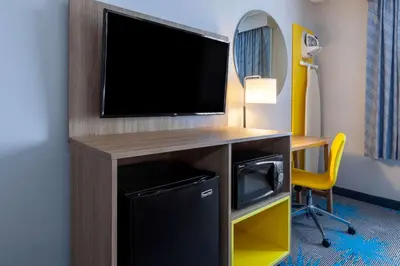 a room with a tv and a desk with a computer at Days Inn by Wyndham Sandusky Cedar Point in Sandusky