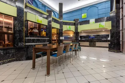 a restaurant with a wooden table and chairs at Days Inn by Wyndham Sandusky Cedar Point in Sandusky