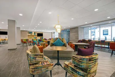 a lobby with chairs and tables in a building at Home2 Suites By Hilton Richmond in Richmond