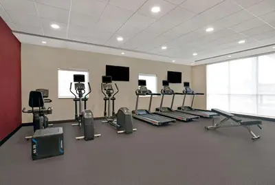 a gym with a row of treadms and cardio machines at Home2 Suites By Hilton Richmond in Richmond