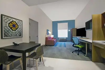 a living room with a table and chairs in a room at Home2 Suites By Hilton Richmond in Richmond