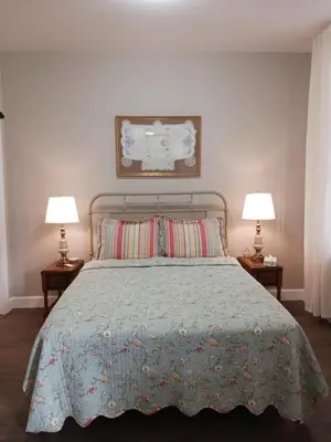 a bedroom with a bed with two lamps on two tables at Lee House Inn in Maysville
