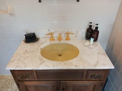 a bathroom sink with a marble counter top at Lee House Inn in Maysville