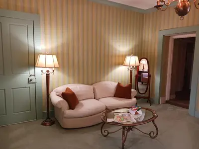 a living room with a white couch and a table at Lee House Inn in Maysville