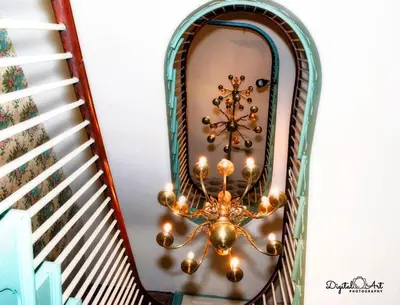 a chandelier hanging from a stairway in a house at Lee House Inn in Maysville