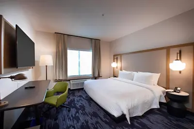 a hotel room with a large white bed and a desk at Fairfield Inn & Suites by Marriott Dayton North in Murlin Heights
