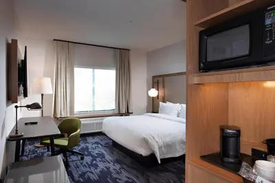 a hotel room with a bed and a desk and a television at Fairfield Inn & Suites by Marriott Dayton North in Murlin Heights