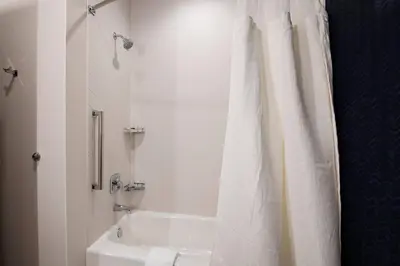 a bathroom with a tub and a white shower curtain at Fairfield Inn & Suites by Marriott Dayton North in Murlin Heights