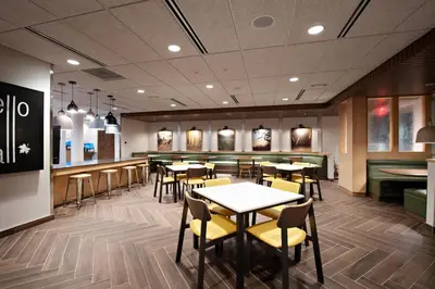 a restaurant with tables and chairs and a bar at Fairfield Inn & Suites by Marriott Dayton North in Murlin Heights