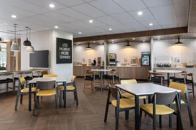 a restaurant with tables and chairs and a counter at Fairfield Inn & Suites by Marriott Cleveland Tiedeman Road in Brooklyn