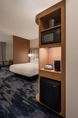 a hotel room with a bed and a television at Fairfield Inn & Suites by Marriott Cleveland Tiedeman Road in Brooklyn