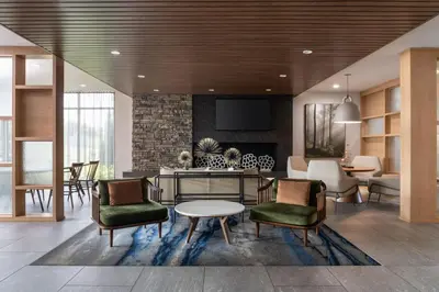 a lobby with a living room with a table and chairs at Fairfield Inn & Suites by Marriott Cleveland Tiedeman Road in Brooklyn