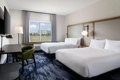 a hotel room with two beds and a desk at Fairfield Inn & Suites by Marriott Cleveland Tiedeman Road in Brooklyn