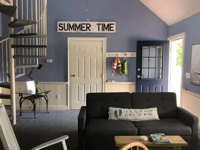 a living room with a couch and a sign on the wall at Chapman House in Put-in-Bay