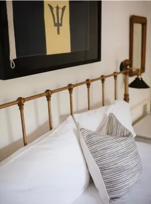 a bed with white pillows and a picture on the wall at Chapman House in Put-in-Bay