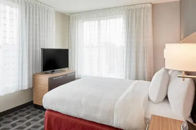 a bedroom with a bed and a flat screen tv at TownePlace Suites by Marriott Columbus North - OSU in Columbus
