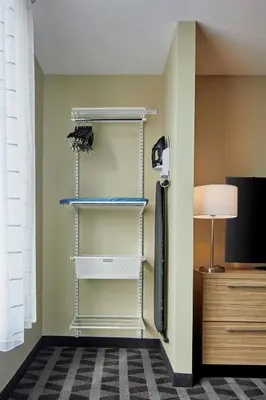 a room with a closet with shelves and a tv at TownePlace Suites by Marriott Columbus North - OSU in Columbus