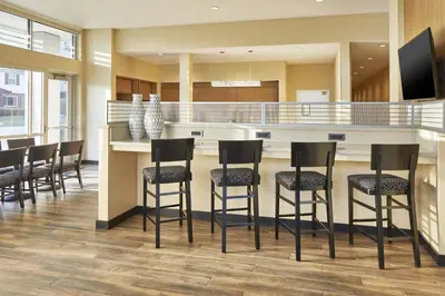 a kitchen with a bar with black stools at TownePlace Suites by Marriott Columbus North - OSU in Columbus