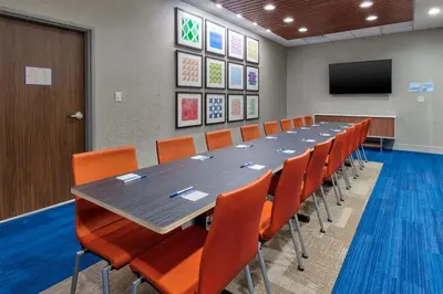 a conference room with a long table and orange chairs at Holiday Inn Express & Suites Wooster by IHG in Wooster