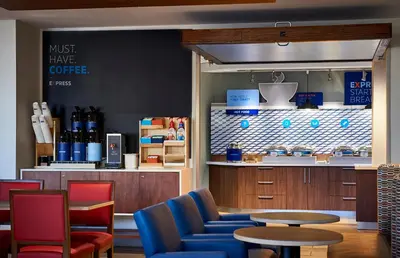 a coffee shop with blue chairs and a table at Holiday Inn Express & Suites Dayton East - Beavercreek by IHG in Beavercreek