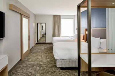 a hotel room with two beds and a mirror at SpringHill Suites by Marriott Columbus Dublin in Dublin