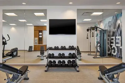 a gym with a flat screen tv and weights at SpringHill Suites by Marriott Columbus Dublin in Dublin