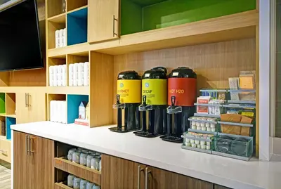 a shelf with a bunch of bottles on it at Home2 Suites By Hilton Springdale Cincinnati in Springdale