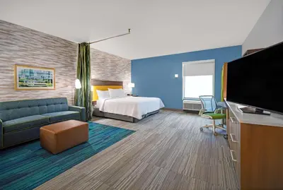 a hotel room with a bed and a flat screen tv at Home2 Suites By Hilton Springdale Cincinnati in Springdale