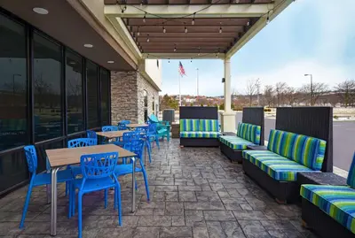 a patio with blue and green chairs and tables at Home2 Suites By Hilton Springdale Cincinnati in Springdale
