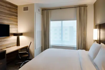 a hotel room with a bed and a desk and a window at Residence Inn by Marriott Columbus Airport in Columbus