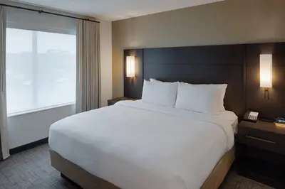 a large bed in a hotel room with a large window at Residence Inn by Marriott Columbus Airport in Columbus