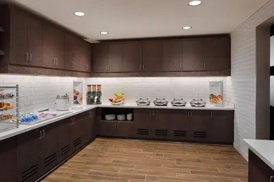 a kitchen with brown cabinets and a counter top at Residence Inn by Marriott Columbus Airport in Columbus