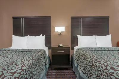 a hotel room with two beds and a lamp at Days Inn by Wyndham Maumee/Toledo in Maumee