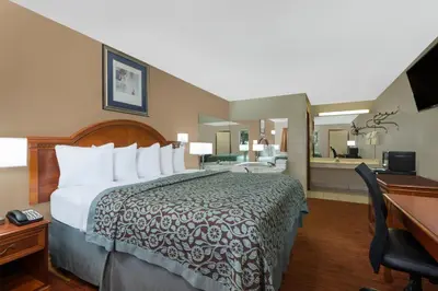 a hotel room with a bed and a desk at Days Inn by Wyndham Maumee/Toledo in Maumee