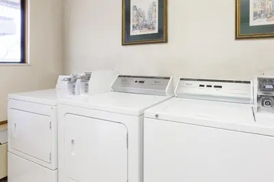 two washing machines sitting next to each other in a laundry room at Days Inn by Wyndham Maumee/Toledo in Maumee