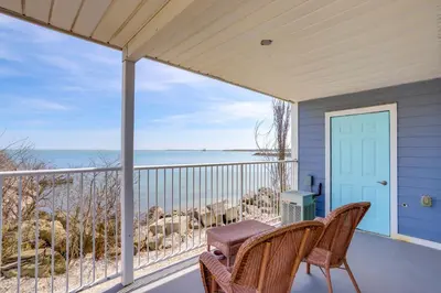 a porch with two wicker chairs and a view of the ocean at Waterfront Bass Island Retreat with Balcony and TV in Put-in-Bay