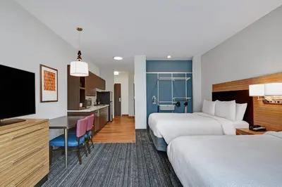 a hotel room with two beds and a kitchen at TownePlace Suites by Marriott Columbus Dublin in Dublin