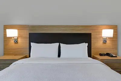 a bedroom with a large bed with two lamps at TownePlace Suites by Marriott Columbus Dublin in Dublin