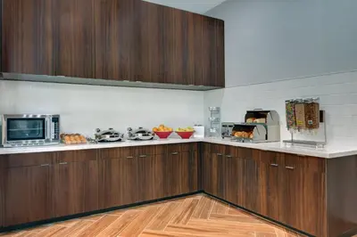 a kitchen with wooden cabinets and a microwave at TownePlace Suites by Marriott Columbus Dublin in Dublin
