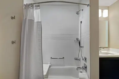 a white bathroom with a shower and a sink at TownePlace Suites By Marriott Lima in Lima