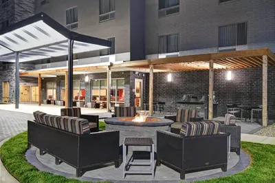 a patio with chairs and a fire pit in front of a building at TownePlace Suites By Marriott Lima in Lima