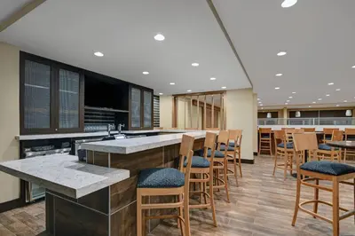 a lobby with a bar with chairs and tables at TownePlace Suites By Marriott Lima in Lima