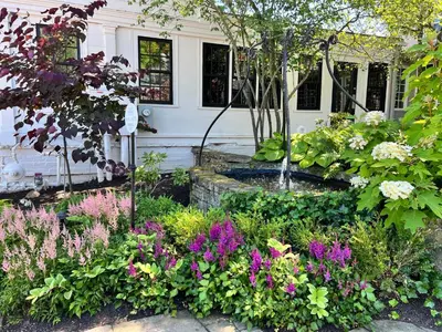 a garden with flowers in front of a house at Inn of Chagrin in Chagrin Falls