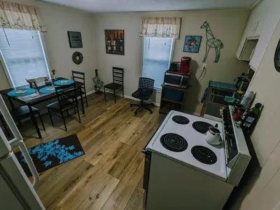 a kitchen with a stove and a table with chairs at The Estate Loft in Downtown Milford in Milford